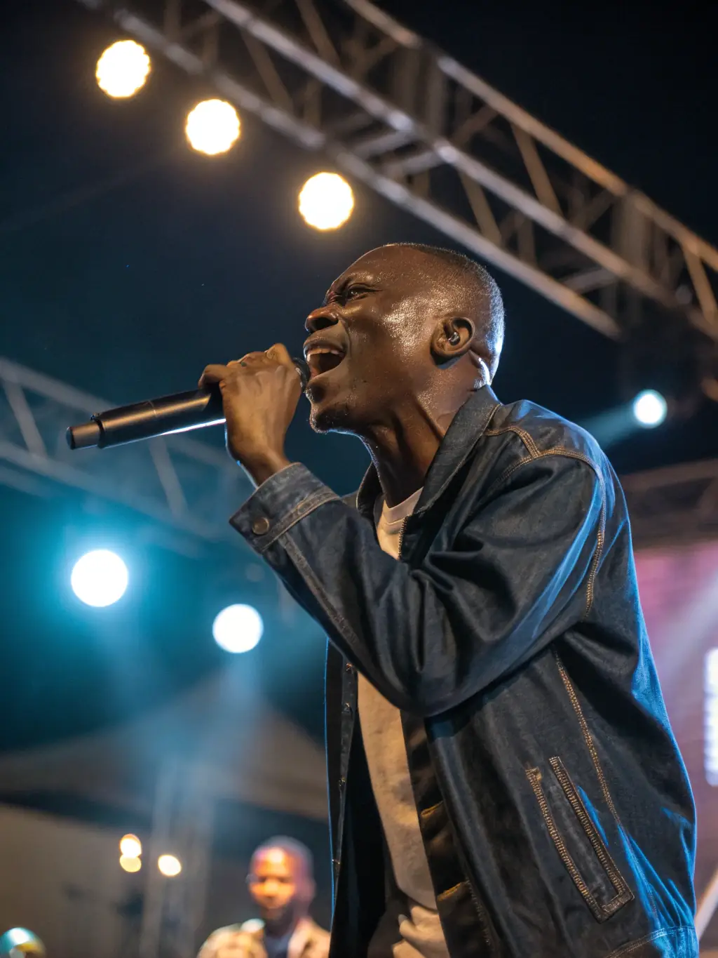 A dynamic photo of an African artist performing on stage at an MYDL-organized concert, capturing the energy and cultural richness of the event.